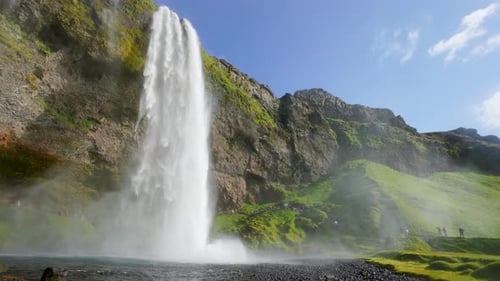 Seljalandsfoss Waterfall Iceland with Rainbow and Green Cliffs.