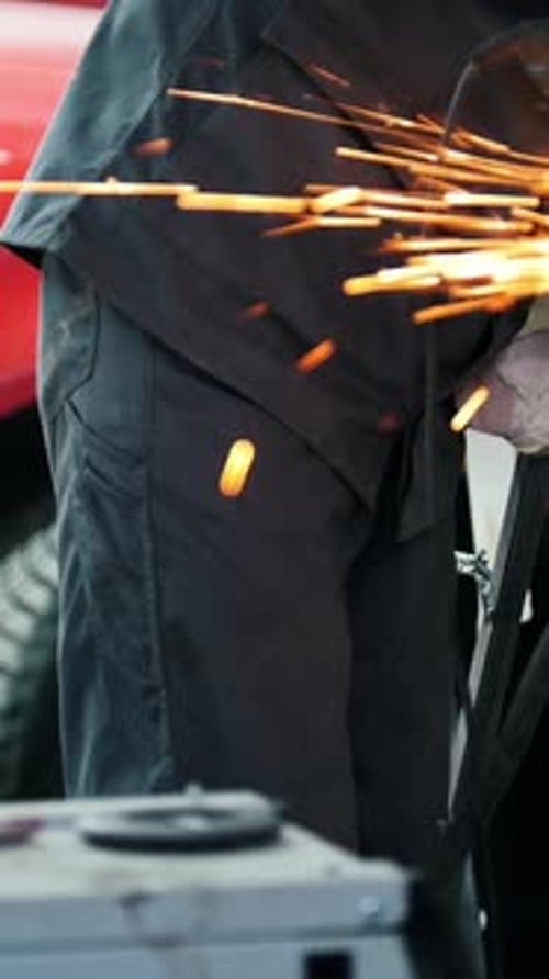 Auto Mechanic at Car Station Grinding Metal Construction with Circular