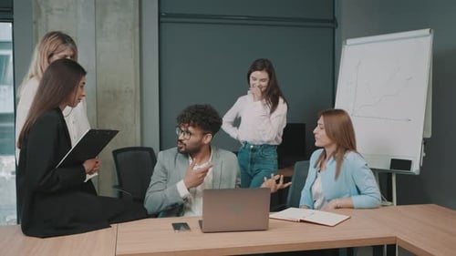 Discussion about business strategies among team members in an office setting with charts