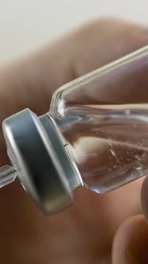 Un professionnel de la santé extrait le médicament liquide du flacon à la seringue