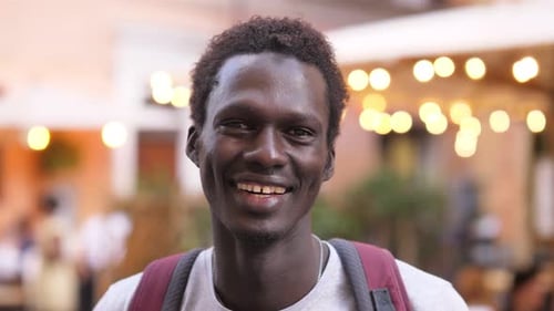 positivity, happiness - young african man on the street laughs at the camera