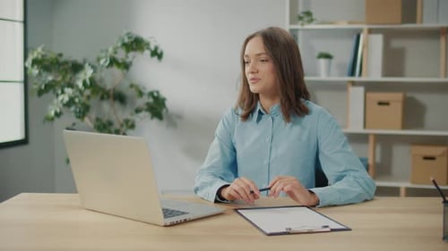 Young Woman Teleconferencing from Home Office