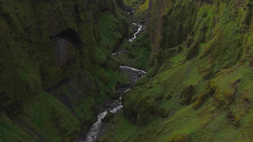 Aerial View of Moss Covered Canyon with River and Waterfall in Iceland