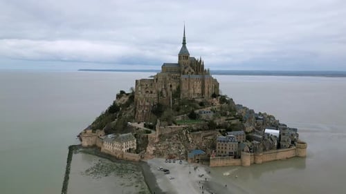 Cinematic view of Mont Saint Michel during low tide, Normandy in France. Aerial drone