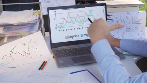 Man Looks at Rising Graphs at the Office