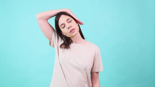 Woman Stretching Neck Against Blue Background