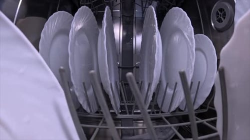 Dishes Being Washed in Dishwasher with Spraying Water