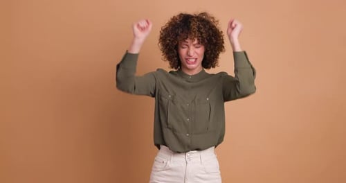 Excited Young Woman Clapping Hands and Smiling on Beige Background