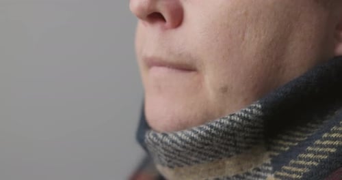 Adult Using Throat Spray to Soothe Sore Throat