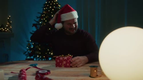 Young Man Falls Asleep At Night Making Christmas Gifts On Desk