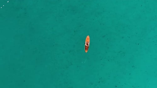 Drone overhead view of a stand-up paddle board in a beautiful turquoise sea.