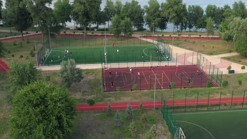 People Training on Openair Football and Basketball Courts in the Park