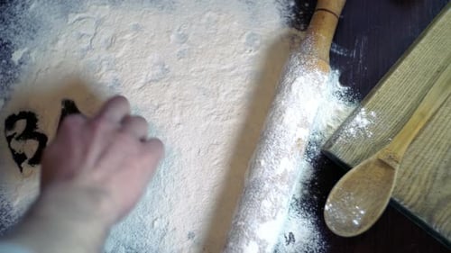 Inscription Bakery on White Flour Spills on the Kitchen Table. Bakery Concept