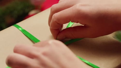 Hands Tying Ribbon on Christmas Gift