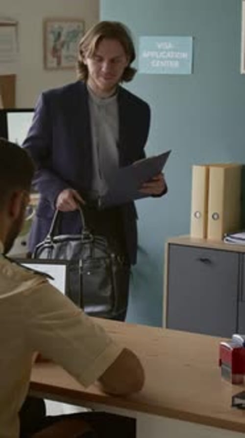 Vertical of Young Male Applicant in Formalwear Visiting Visa Center