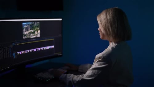 Woman Editing Video Late at Night on Computer