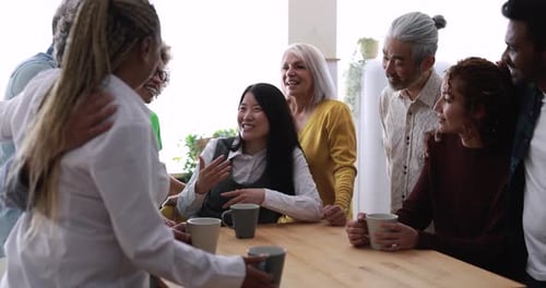 Diverse Group Chatting Over Coffee at Wooden Table