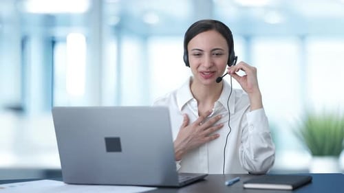 Happy Indian call center girl talking to the customer