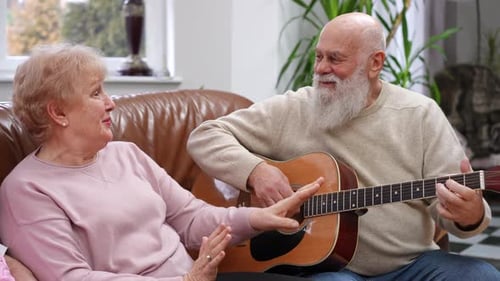 Senior Couple Sings and Plays Guitar at Home