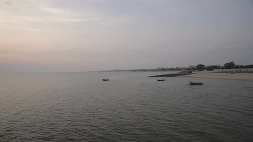 Vista tranquila da praia com cais que se estende até a água sob céu nublado