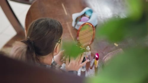 Closeup Blurred View of Girl Applying Makeup with Beauty Products on Table