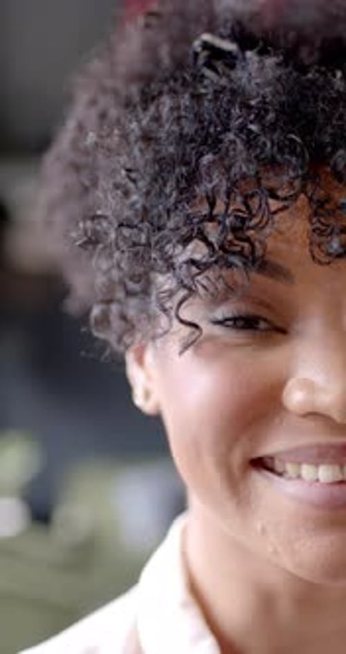 Vertical video of portrait of smiling african american businesswoman in office with copy space