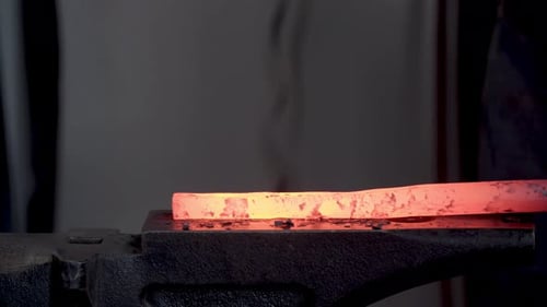 Hammering Red-Hot Metal Bar on Anvil