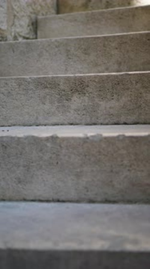 Vertical video climbing stairs, close-up, stone, old building