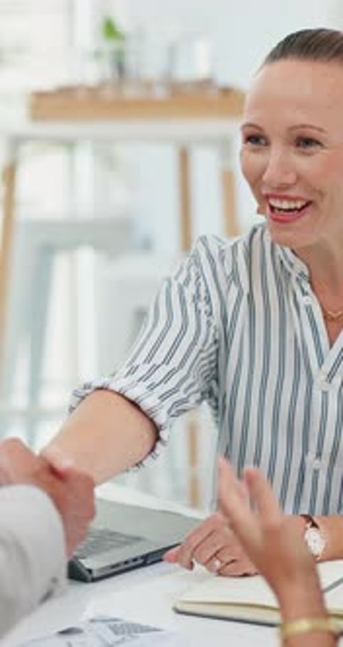 Business woman, meeting and applause with handshake for interview, deal or agreement at office desk