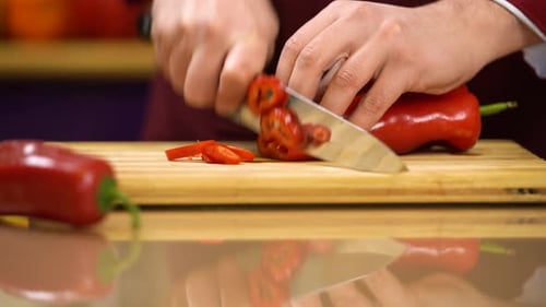 Person Cutting a Fresh Red Bell Pepper