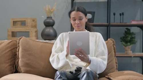 Young Woman Using Tablet on Couch at Home