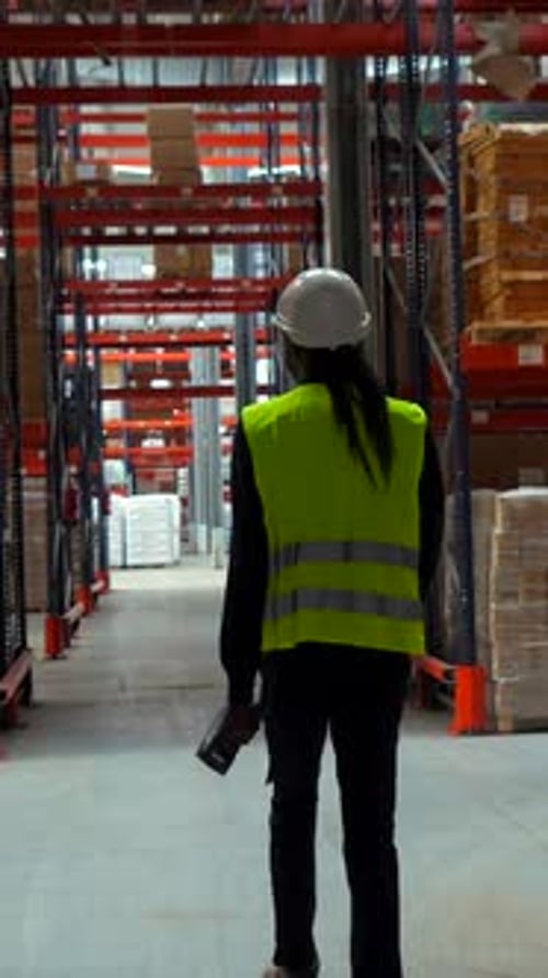 Logistics Operator Walking Through Warehouse Scanning Packages