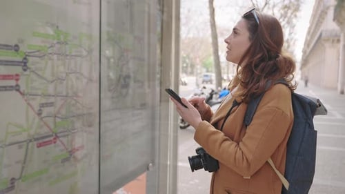 Woman Looking at City Map on Street with Phone