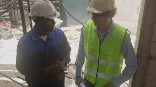 Architects Reviewing Blueprints at Construction Site