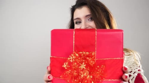 Woman Smiles Holding Christmas Gift Close Up