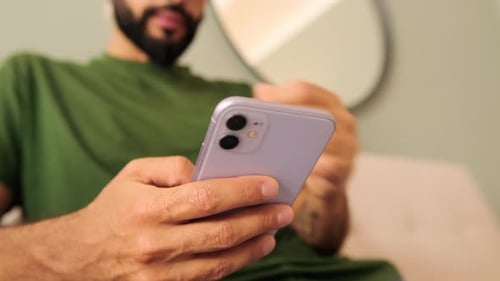 Close-up of a young man's hands holding a mobile phone