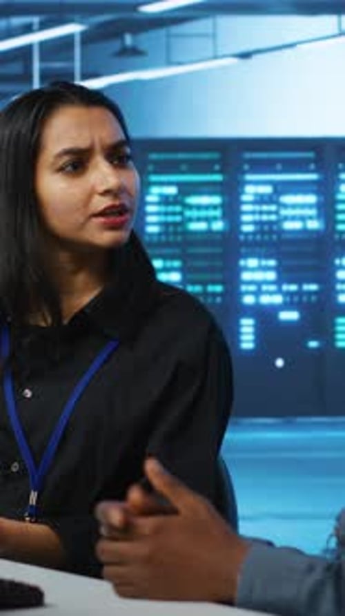 Vertical Video Coworkers in Data Center Looking Over Annual Systems Review Documents