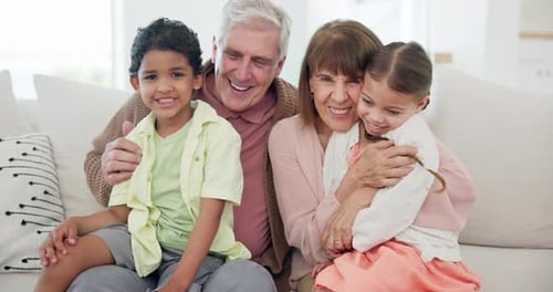 Grandparents and Grandchildren Smiling Together on a Sofa