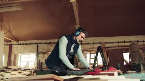 A Man Worker in the Carpentry Workshop, Working with Wood