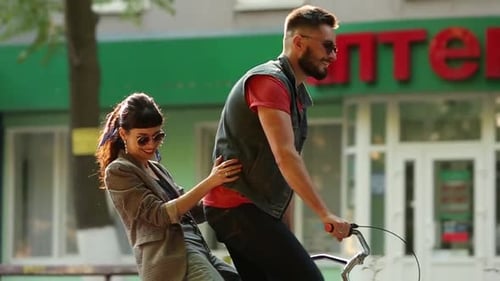 Jovem casal andando de bicicleta juntos no parque Namorado romântico andando de bicicleta com namorada feliz