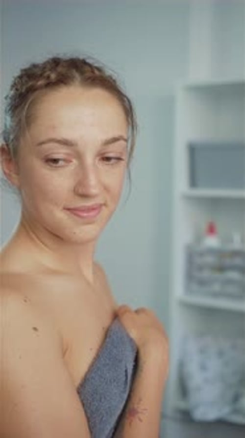 Young Woman Wrapped in a Towel in Bathroom