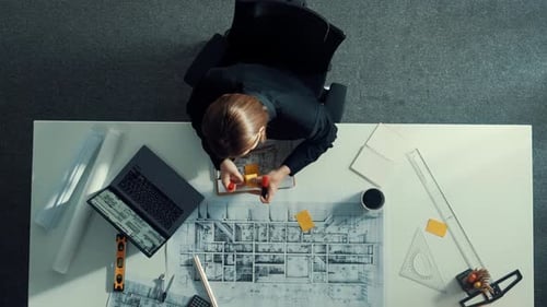 Luftaufnahme einer Architektin, die bei der Arbeit am Laptop zeichnet. Ernährung.