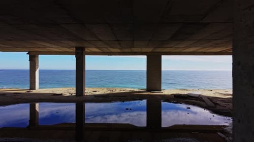 Aerial view of a coastal abandoned structure with water reflections