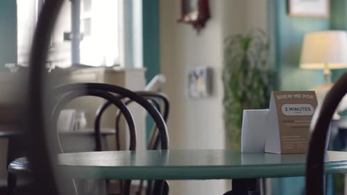 A slow panning shot across tables, chairs and customers in a trendy cafe | Gourmet Coffee House | Sh