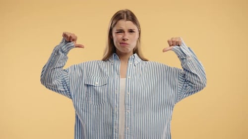 Young Woman With Dislike Sign Stylish Lady Showing ThumbsDown On Beige Studio