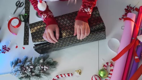 Woman Wrapping Christmas Gift in Festive Paper