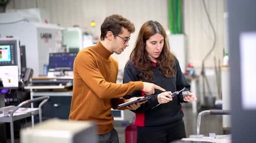 Engineers Talking While Using Digital Tablet in a Modern Factory