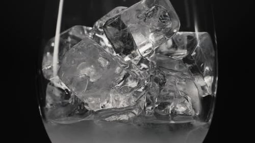 Refreshing Ice Cubes Fill Glass with Water
