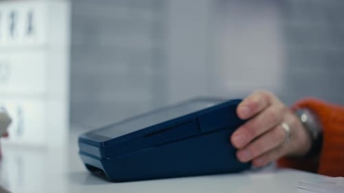 Nahaufnahme Eine Frau bezahlt mithilfe der NFC-Technologie mithilfe eines Mobiltelefons NFC in einem Mobiltelefon