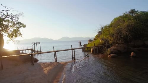 Woman Enjoying Tropical Island Sunset From Pier